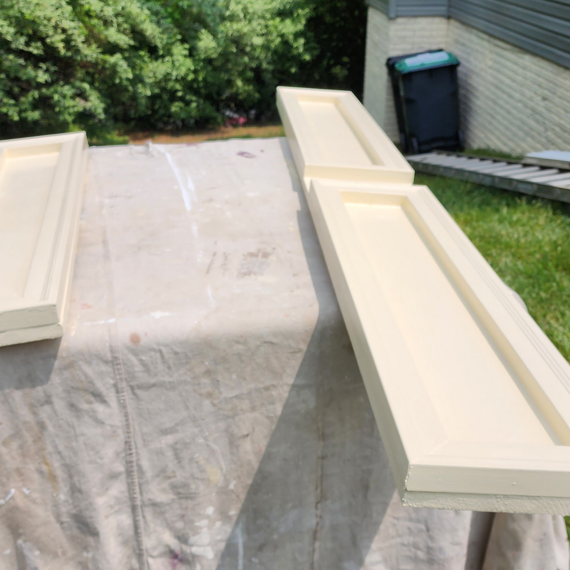 Painted trim pieces drying outside during a home repair project