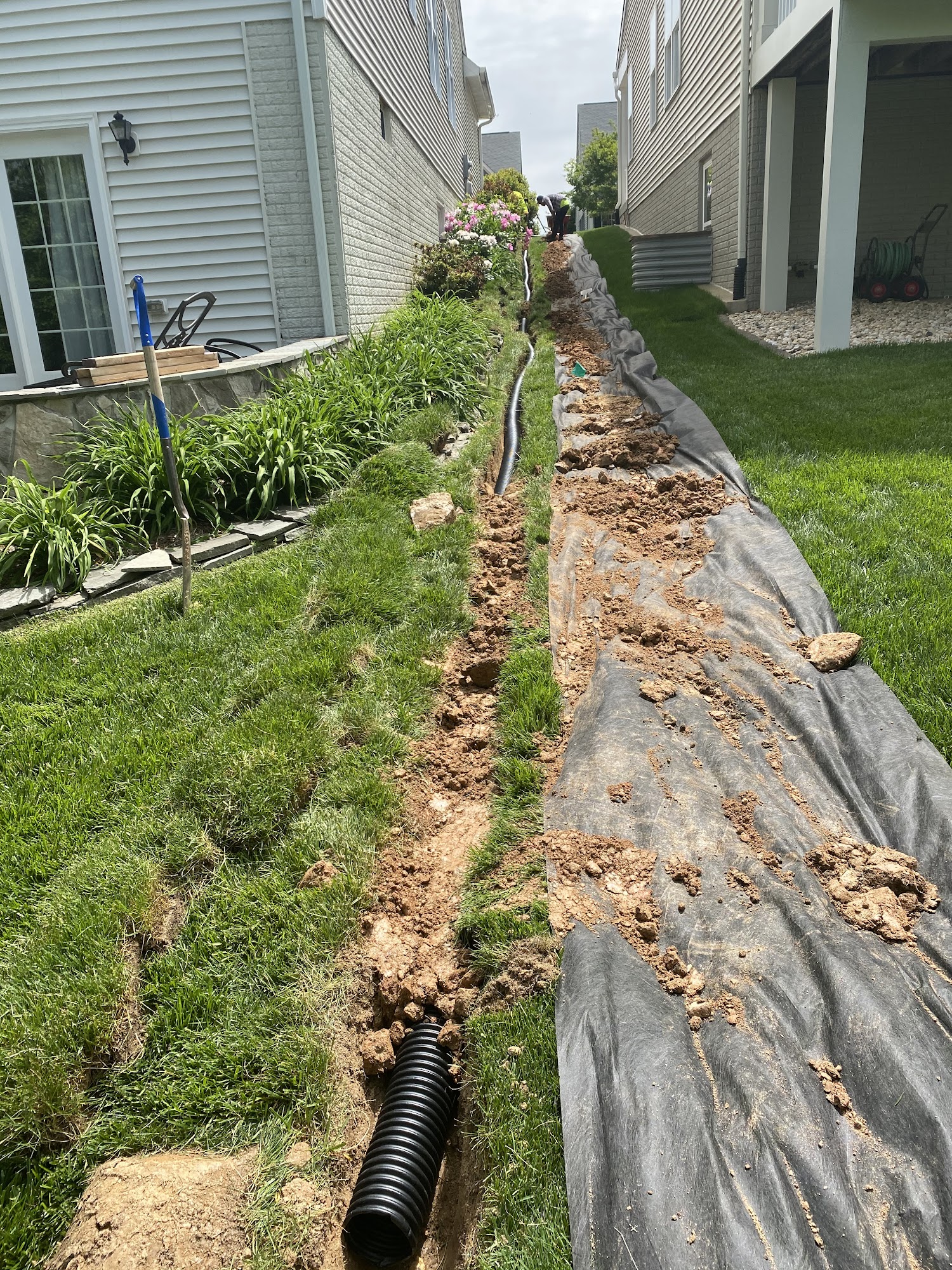 Drainage pipe installation trench between two homes