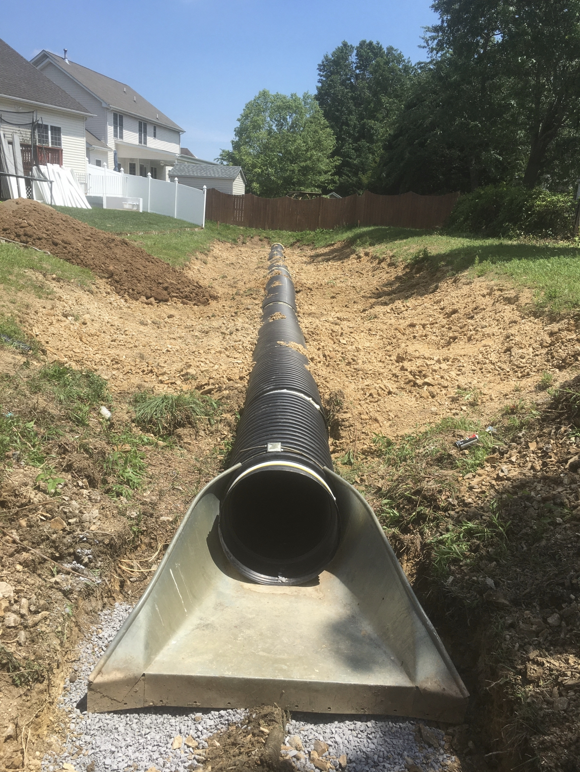 Large drainage pipe being installed in a yard trench